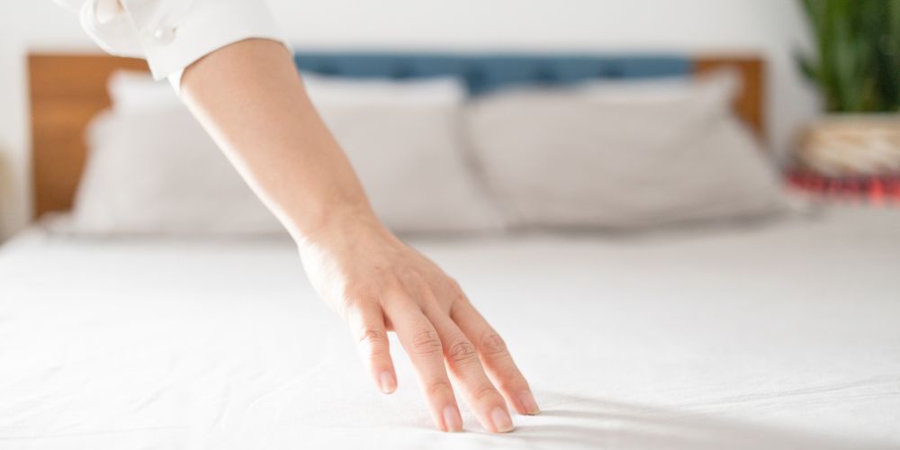 Homeowner touching a clean white mattress