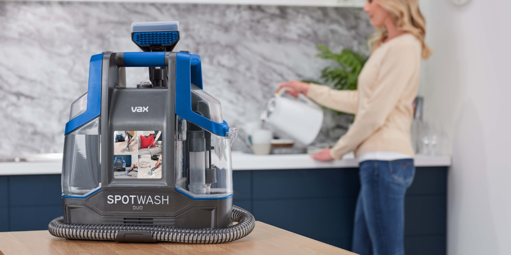 Shot of a woman in a kitchen with a Vax Spotwash cleaner in the foreground