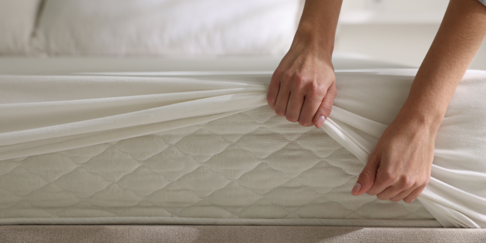 Removing a mattress topper from a white mattress