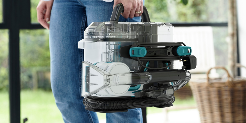Woman carrying a Vax spotwasher